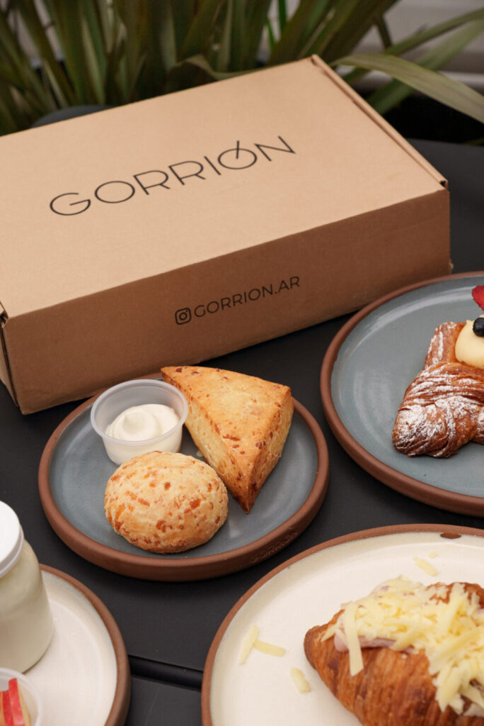 Chipá y scon de queso con queso crema frente a la caja Gorrión