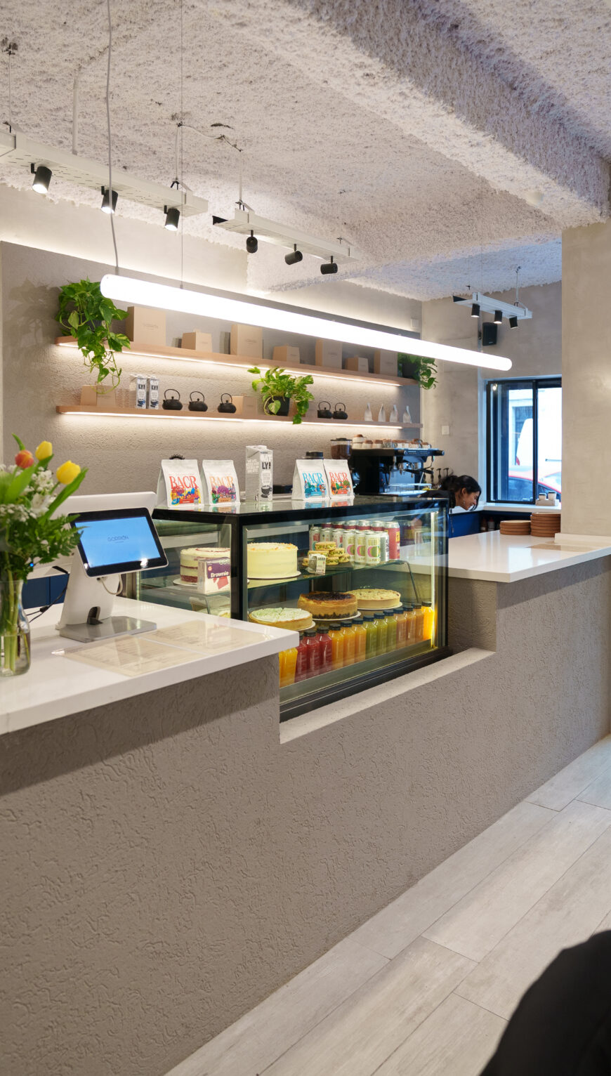 Mostrador de un local Gorrión con vitrina de pastelería, café en grano y jugos naturales